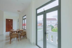 a dining room with a table and glass doors at ROSA VILLA & HOTEL Dalat in Da Lat