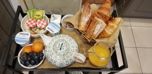 una bandeja de comida con pan y fruta y un vaso de zumo de naranja. en Le Vieux Tilleul, en Vaires-sur-Marne