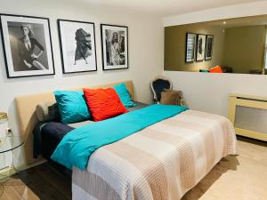Un dormitorio con una cama con almohadas de colores. en Red light district B & B canal view en Ámsterdam