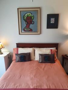 a bedroom with a bed with an orange comforter at Weekend Vikings in Port Shepstone