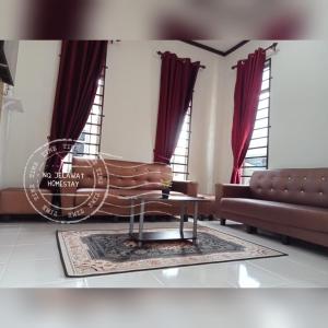 uma sala de estar com um sofá e uma mesa em NQ Jelawat HOMESTAY em Bachok