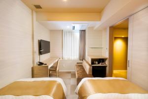 um quarto de hotel com duas camas e uma televisão em Best Western Hotel Fino Tokyo Akasaka em Tóquio