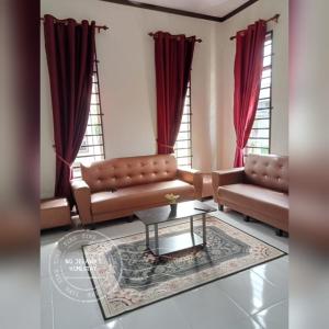 uma sala de estar com dois sofás e uma mesa em NQ Jelawat HOMESTAY em Bachok