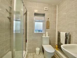 a bathroom with a toilet and a sink and a shower at Tong Apartments in Leeds