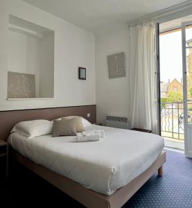 a bedroom with a bed and a large window at HOTEL KAN AVEL in Saint-Lunaire