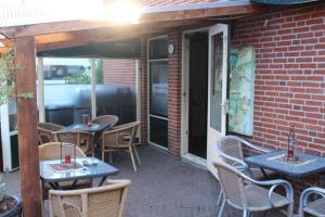 een patio met tafels en stoelen in een bakstenen gebouw bij Hotel,cafe,biljart POT in Groenlo