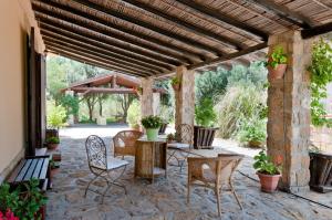 eine Außenterrasse mit einer hölzernen Pergola und Stühlen in der Unterkunft Geranio Rosso in Pergusa