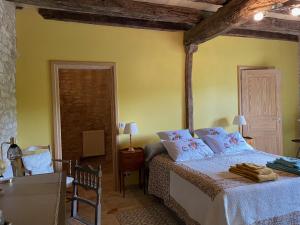 sypialnia z łóżkiem w pokoju z żółtymi ścianami w obiekcie Domaine de Galoubet Lot w mieście Beaumat