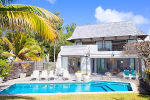 a villa with a swimming pool in front of a house at Peter's Beach House in Poste Lafayette