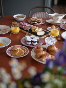a table with plates of food and glasses of orange juice at La Maison de Jacqueline in Vosne-Romanée