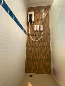 a shower in a bathroom with a tile wall at Nangnon Hill Hug Hotel in Ban Pa Muat