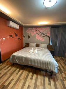 a bedroom with a bed with two towels on it at Nangnon Hill Hug Hotel in Ban Pa Muat
