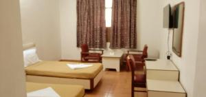 a hotel room with a bed and a table and chairs at Hotel Ranjit Residency in Hyderabad