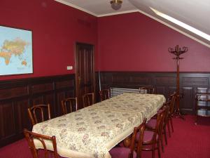 ein Esszimmer mit einem Tisch, Stühlen und roten Wänden in der Unterkunft Adler Hotel in Budaörs