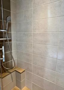 a bathroom with a shower with a tile wall at HOTEL KAN AVEL in Saint-Lunaire +31 photos