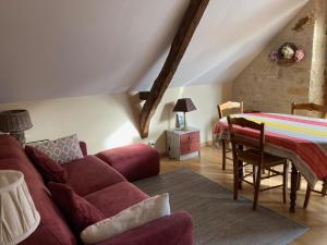 een woonkamer met een rode bank en een tafel bij Domaine de Galoubet, Lot , Gîtes de charme in Beaumat