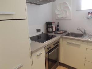 a small kitchen with a sink and a refrigerator at Design Studio Cap Rubio Ibiza in Na Xamena