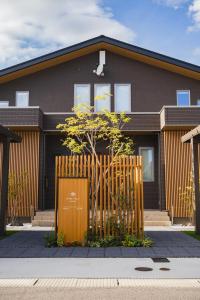 una casa con una valla de madera delante de ella en マークヴィラ諏訪湖 siteB en Shimo-suwa