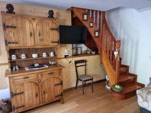 Habitación con escalera, silla y TV. en CASA NONNA RINA en Alagna Valsesia