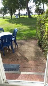 two blue benches sitting next to a table in a park at Das Landhaus am Haff LHH B09 in Stolpe