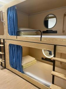 Pokój z 2 łóżkami piętrowymi i lustrem w obiekcie Timehouse Hong Kong Hostel Group w Hongkongu