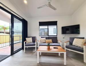 a living room with a couch and a table at Club Byron Accommodation in Byron Bay