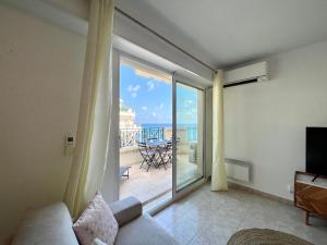 a living room with a couch and a large sliding glass door at "Le Victoria Beach" Vue Mer Plein Centre, Spacieux in Menton