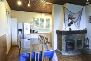 a kitchen with a dining table and a fireplace at L'Escapade in Rayol-Canadel-sur-Mer