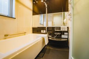 a bathroom with a tub and a sink at マークヴィラ諏訪湖 siteB in Shimo-suwa