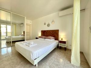 a bedroom with a large bed and a mirror at "Le Victoria Beach" Vue Mer Plein Centre, Spacieux in Menton