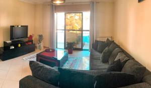 a living room with a couch and a tv at Viana do Castelo, Cabedelo Beach Apartment in Viana do Castelo
