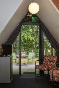 ein Wohnzimmer im Dachgeschoss mit einem großen Glasfenster in der Unterkunft Hotelhuisjes Aartswoud in Aartswoud