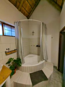 a large white tub in a bathroom with a window at El Morado Guest Farm in White River