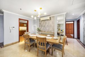 a dining room with a wooden table and chairs at VIVEKA by Kozystay - SCBD in Jakarta