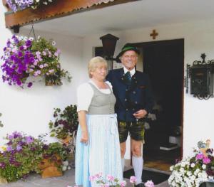 un hombre y una mujer parados frente a una puerta en Pension Herzoghäusel, en Bischofswiesen