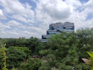 a blue building in the middle of trees at Shanti Residency in New Delhi