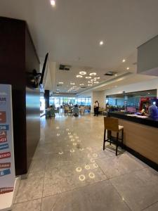 a lobby of an airport with a counter and chairs at Beach Class Internacional apartamento in Recife +29 photos