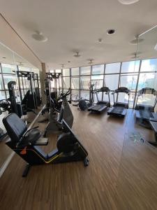 a gym with treadmills and ellipticals in a building at Beach Class Internacional apartamento in Recife