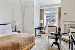 a hotel room with a bed and a desk at Lausanne Palace in Lausanne