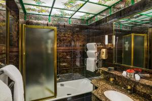 La salle de bains est pourvue d'une baignoire, d'un lavabo et d'un miroir. dans l'établissement Lausanne Palace, à Lausanne