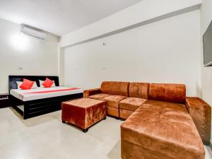 a living room with a couch and a bed at OYO 85559 The Nine's in Patna