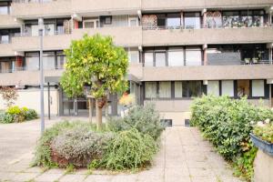 an apartment building with a tree in front of it at Apartment Neuss-Düsseldorf Messe, Balkon, Küche in Neuss