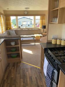 a kitchen with a stove and a living room at 367 Caravan in Stevenston