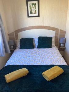 a bed with two pillows and two towels on it at 367 Caravan in Stevenston