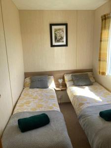 a room with three beds and a table with a window at 367 Caravan in Stevenston