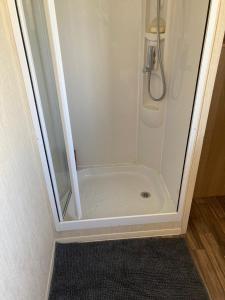 W łazience znajduje się prysznic ze szklanymi drzwiami. w obiekcie 367 Caravan w mieście Stevenston