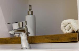 um lavatório de casa de banho com uma torneira e uma garrafa de sabão em Da Concavo e Convesso em Locorotondo