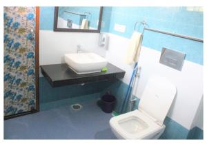 La salle de bains est pourvue d'un lavabo et de toilettes. dans l'établissement Kishkindha Wild 3BHK, à Rāmnagar