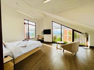 a bedroom with a large bed and large windows at Lasol Boutique Hotel in Da Lat