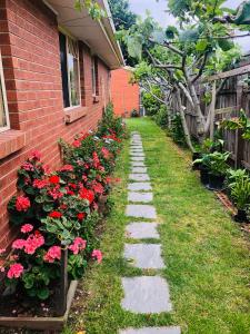 瑪莎山的住宿－Charlie sweet home at Mornington Peninsula，一座花园小径,旁边是一座红花